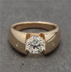 a yellow gold ring with a diamond in the center