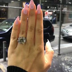 a woman's hand with pink manicures and a diamond ring