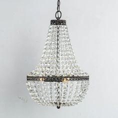 a chandelier hanging from the ceiling with crystal beads and black metal fittings