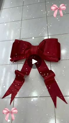 a red bow on the floor with pink bows around it