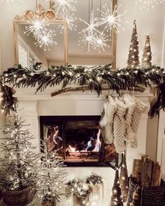 a fireplace decorated for christmas with stockings and trees