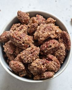 a bowl filled with nuts sitting on top of a table next to other food items