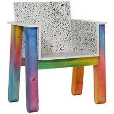 a white chair with multicolored legs and a seat made out of concrete blocks