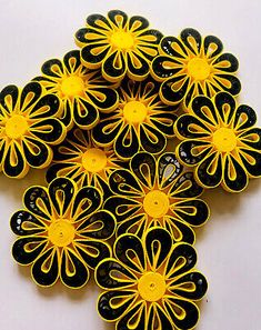 yellow and black flowers are arranged on a white surface