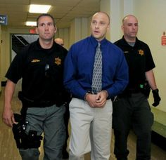 three men in police uniforms are walking down the hallway with their hands on their hips