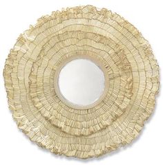 a round mirror made out of wicker on a white surface with a reflection in the center