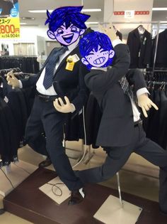 two mannequins dressed in suits and ties with blue hair are posed for the camera