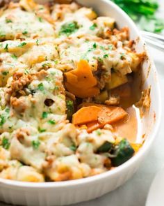 a casserole dish with meat, cheese and veggies in it on a table