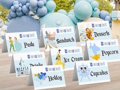 a table topped with lots of place cards next to balloons and snowflakes in the background