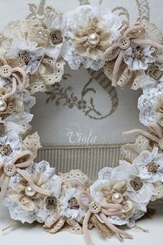 a close up of a wreath made out of lace and flowers on a white background