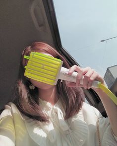 a woman is brushing her teeth with an electric toothbrush while sitting in a car