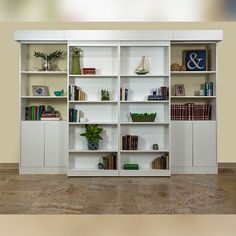 a white bookcase filled with lots of books on top of a hard wood floor