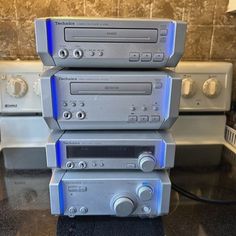 three stereos stacked on top of each other in front of a microwave and oven