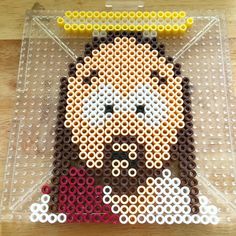 a plastic tray with some beads on it and a lego character made out of them