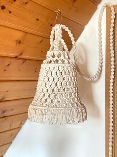 a white crocheted light hanging from a wall