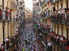 many people are standing on balconies in the street