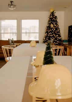 a dining room table with plates on it and a christmas tree in the background