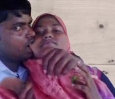 a man is holding a woman in his arms and she is wearing a pink shawl