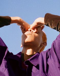 a man is looking up into the sky with his hands on his head