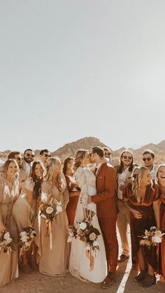 a group of people standing next to each other in front of a desert mountain range