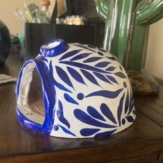 a blue and white vase sitting on top of a wooden table