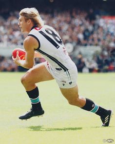 a man running with a ball in his hand on a field during a sporting event