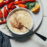 a white plate topped with carrots and dip