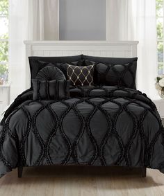 a black comforter set with decorative pillows