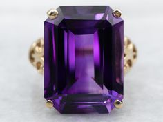 This beautiful vintage filigree setting has an earthy feel, with curling textured motifs repeating in a tapering, lattice-style pattern. Set in the center is a stunning amethyst of the deepest shade of plum and lilac reflecting light to and from the golden filigree. Metal: 10K Yellow GoldGem: Amethyst 11.61 CaratsGem Measurements: 12.4 x 16.9 mm, Emerald CutRing Size: 4.75 Pocket Watch Chain, Watch Chain, Pearl Pendant, Solitaire Ring, Lattice, Cocktail Rings, Beaded Chain, Charm Earrings, Shop Necklaces