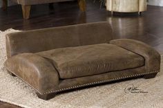 a brown couch sitting on top of a wooden floor