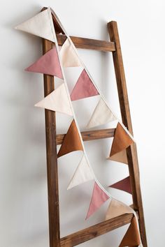 a wooden ladder with pink and white pennants on it