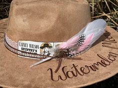 The Lainey Wilson Concert Wide Brimmed Cowgirl Hat is perfect for attending that upcoming Lainey concert... Or just displaying your fan crush!   Colors: Cream Sand (Light Tan) Cognac (Dark Tan) Each hat displays a ticket stub for the Lainey Wilson's Country's Cool Again Tour and a floral arrangement burned-by-hand around the hat brim.  Flowers are just my creative arrangements, but feel free to let me know if you have a specific flower that you would like me to include.  I've had requests for ma Western Hats Concert, Lainey Wilson Concert, Laney Wilson, Watermelon Moonshine, Hat Displays, Girls Crafts, Hat Bar, Concert Attire, Lainey Wilson