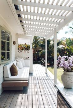 a white couch sitting on top of a wooden floor next to a potted plant