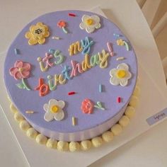 a birthday cake decorated with flowers and letters