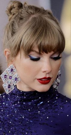 a close up of a person wearing earrings and a dress with sequins on it