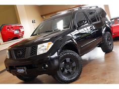 a black truck parked in a garage next to other cars