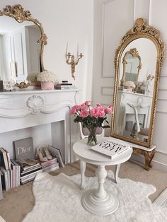 a white table with pink flowers in front of a mirror