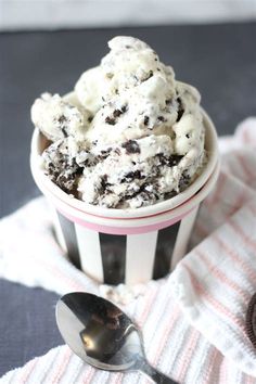 a bowl filled with ice cream on top of a striped cloth next to a spoon