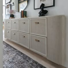 a white dresser sitting next to a mirror on top of a wall