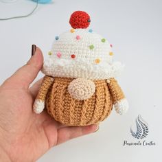 a small crocheted cupcake is in someone's hand