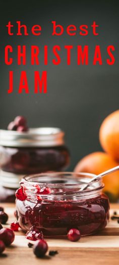 a jar filled with jam sitting on top of a wooden table next to oranges