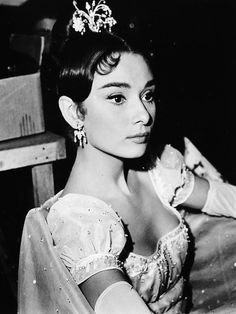 a black and white photo of a woman wearing a tiara