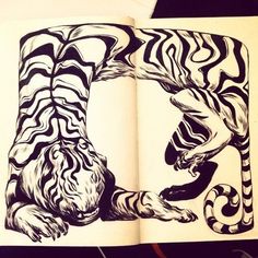 an open book with black and white designs on the pages, depicting a tiger biting another animal's tail