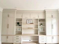 an empty room with white cabinets and drawers