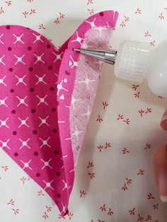 someone is making a heart out of fabric with scissors and glue on the edge of it