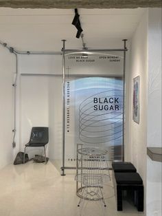 the black sugar sign is hanging in an empty room with chairs and stools next to it