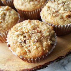 several muffins sitting on top of a wooden cutting board