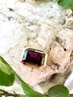 This timeless rhodolite garnet necklace is crafted with expert care and attention to detail. The bezel-set gemstone is set into 14kt yellow gold for a stunning, classic look that will be admired for years to come. This necklace features:-1.50 carat Rhodolite Garnet-Bezel Setting-14KT Yellow Gold -16-18in adjustable chainStyle #235-00109 Earrings Not Included Formal Yellow Gold Garnet Necklaces, Formal Yellow Gold Garnet Necklace, Fine Jewelry Yellow Gold Garnet Necklaces, Formal Yellow Gold Tourmaline Necklaces, Formal Yellow Gold Tourmaline Necklace, Formal Ruby Necklace With Bezel Setting, Classic Garnet Birthstone Necklace, Elegant Yellow Gold Tourmaline Necklace, Elegant Tourmaline Yellow Gold Necklace