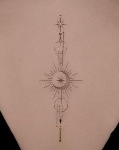 the back of a woman's neck with a sun and moon tattoo on it