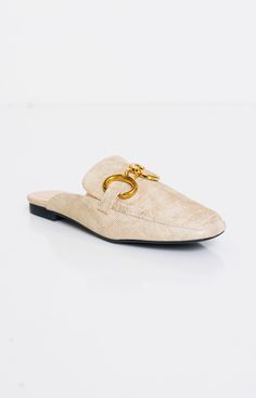 The Andromeda Mules are crafted from a shiny and reflective material, likely metallic faux leather or a metallic finish fabric, in a dazzling gold color. This material adds a touch of luxury and sophistication to the shoes. The mules feature a slip-on design with a closed toe and an open back, characteristic of mule-style shoes. They may have a pointed or rounded toe, depending on the specific design, for a sleek and elegant silhouette. Luxury Closed Toe Elegant Mules, Luxury Slip-on Closed Toe Flats, Luxury Elegant Closed Toe Mules, Luxury Elegant Closed Toe Pointed Flats, Luxury Elegant Pointed Toe Closed Flats, Luxury Sleek Pointed Toe Mules, Luxury Metallic Mules, Luxury Designer Gold Mules, Luxury Sleek Open Toe Mules